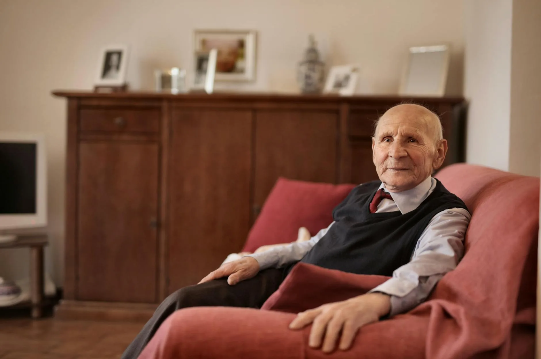 elderly man sitting warmly beside radiator winter
