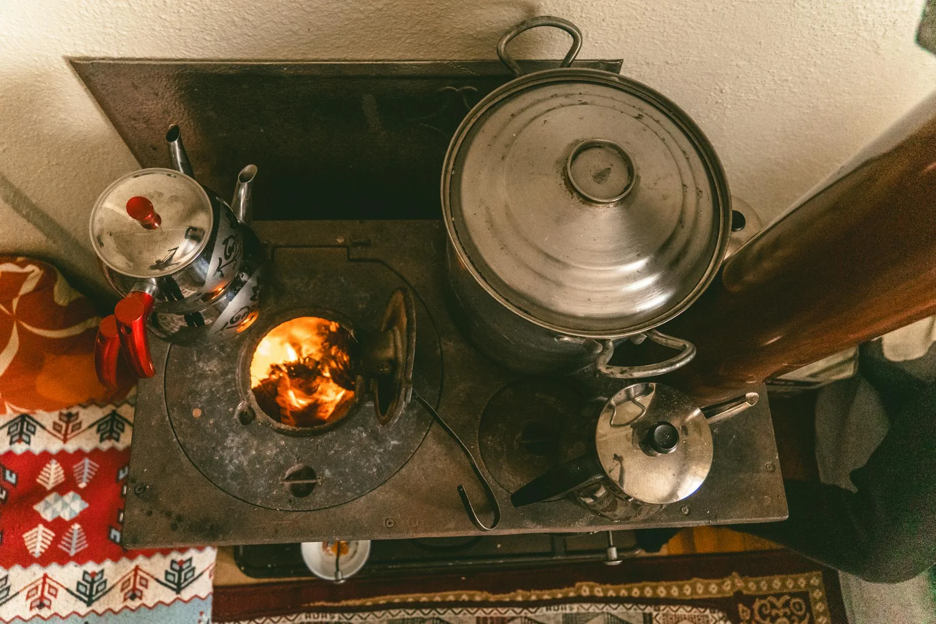 elderly woman warming hands near radiator winter